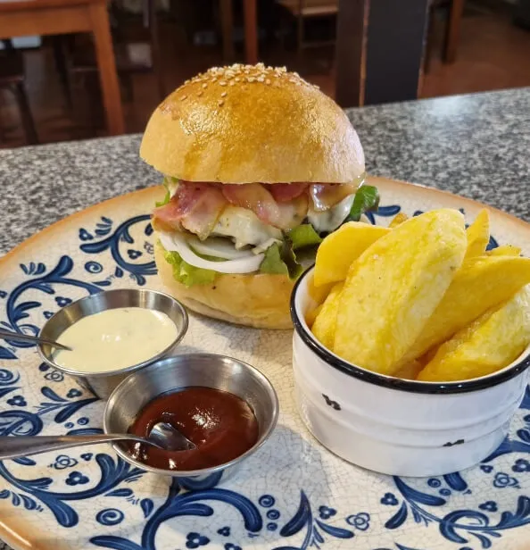 Un plato con una hamburguesa y patatas fritas.