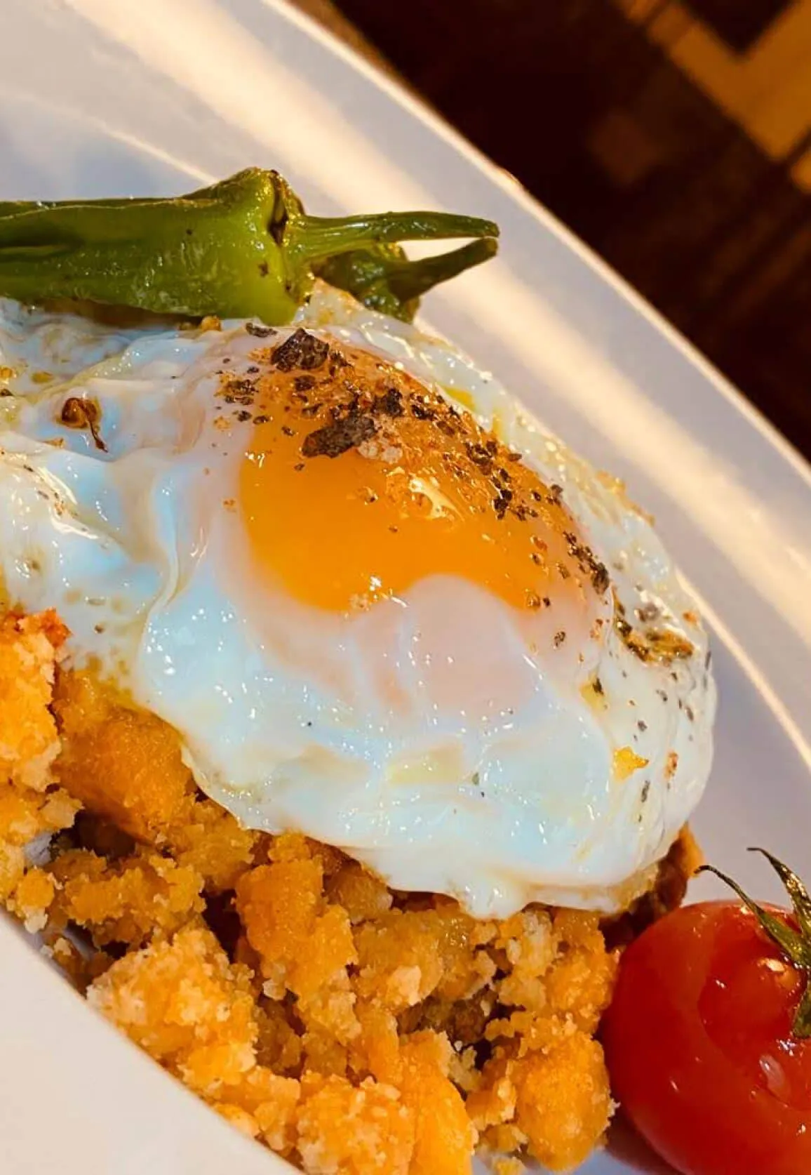 Un plato de migas castellanas con un huevo encima.