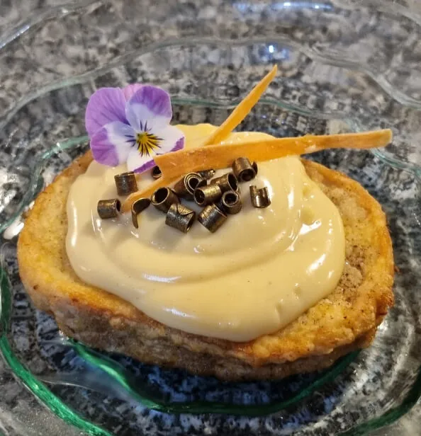 Una torrija de crema con una flor encima.